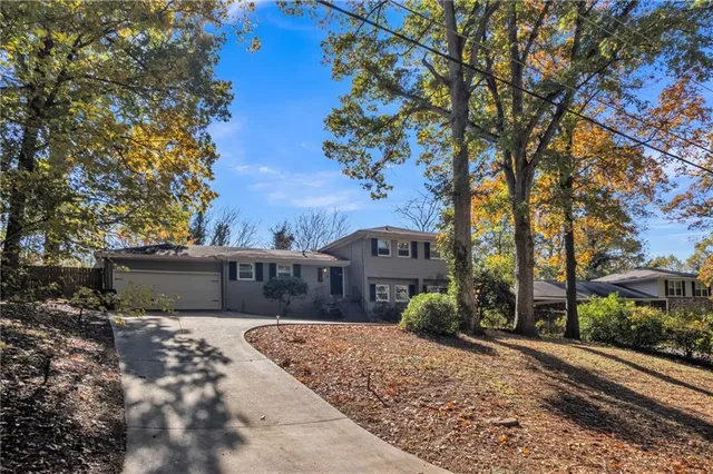 a view of a house with a yard and large trees