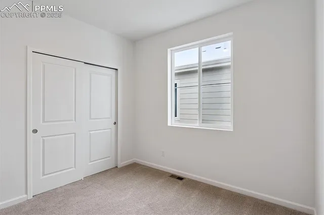 an empty room with windows and closet