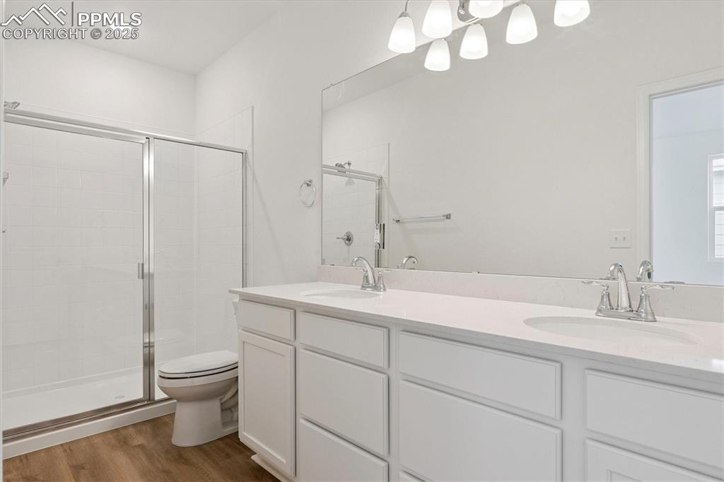 2444 Serviceberry Grove Colorado Springs, CO 80915 - Photo 18 of 21 a bathroom with a toilet a sink and mirror