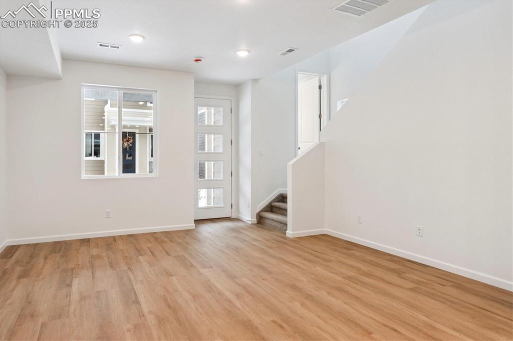2444 Serviceberry Grove Colorado Springs, CO 80915 - Photo 2 of 21 an empty room with wooden floor and windows