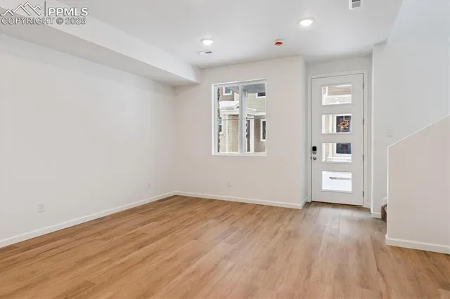 a view of empty room with wooden floor