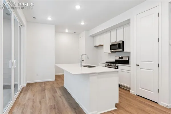 a view of kitchen with sink a microwave and refrigerator