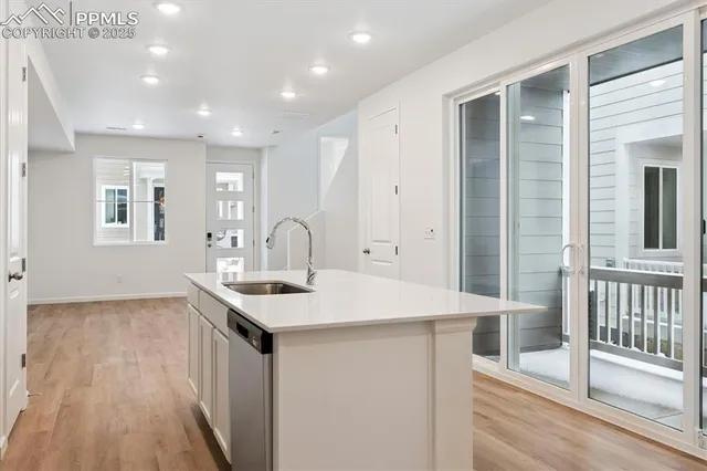 a kitchen that has a sink a window and cabinets