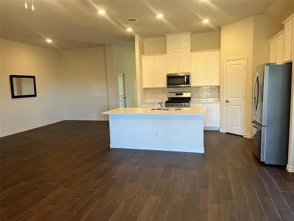 a kitchen with stainless steel appliances a refrigerator and a stove top oven
