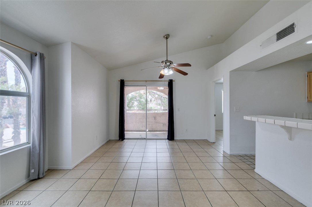7570 West Flamingo Road, Unit 252 Las Vegas, NV 89147 - Photo 13 of 44 Natural light floods this living area, highlighted by soaring vaulted ceilings and durable tile flooring.