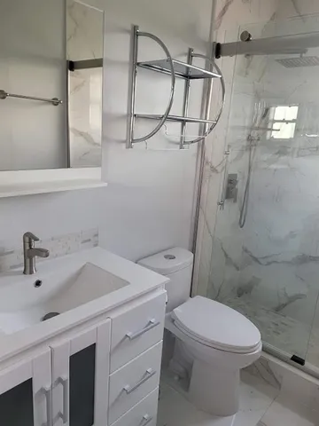 a bathroom with a sink a toilet and shower