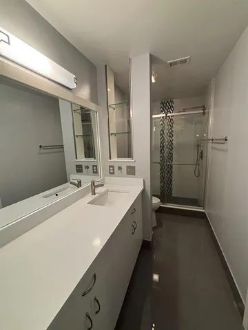 a bathroom with a double vanity sink mirror and shower