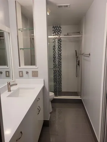 a bathroom with a double vanity sink toilet and shower