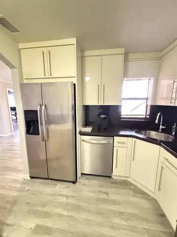 a kitchen with stainless steel appliances a refrigerator sink and microwave