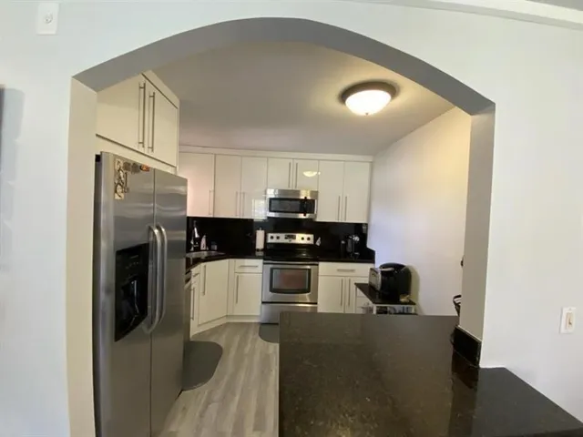 a kitchen with a refrigerator and a stove top oven