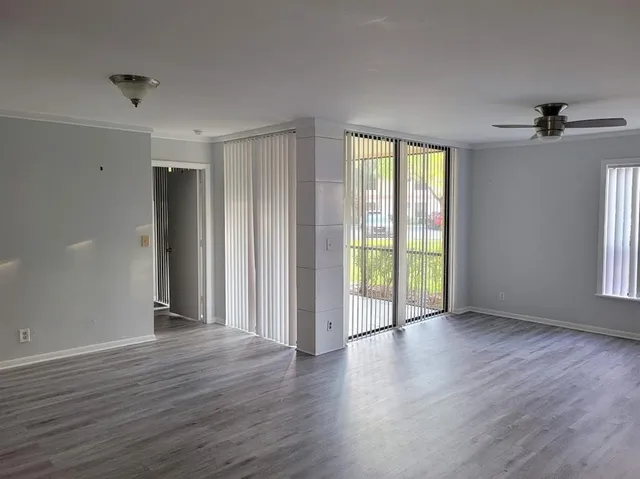 an empty room with wooden floor and windows