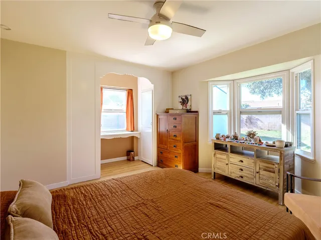 a bedroom with a bed and large windows
