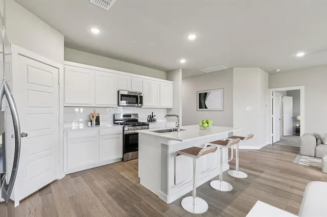a kitchen with stainless steel appliances a refrigerator sink and microwave