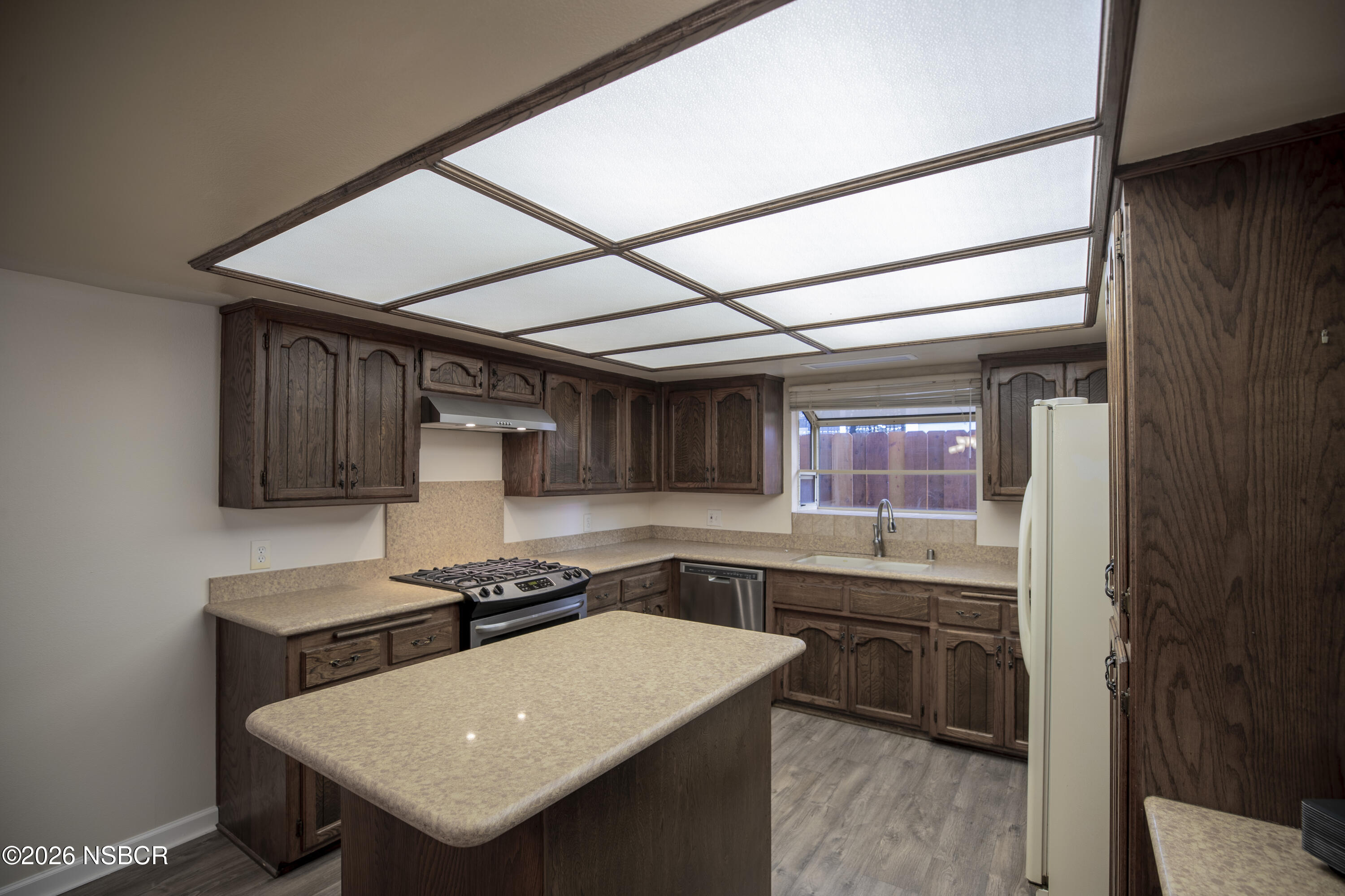 205 South E Street Lompoc, CA 93436 - Photo 9 of 49 a kitchen with a sink a stove and cabinets