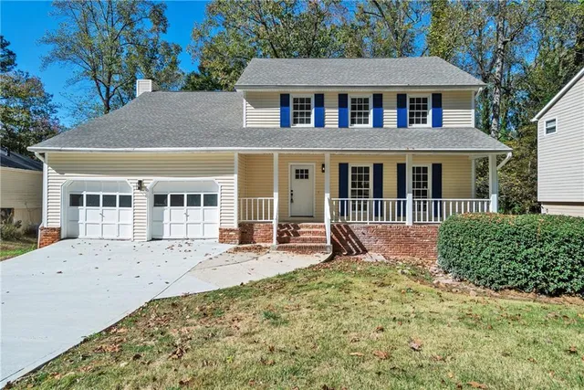 a front view of a house with a yard outdoor seating and garage