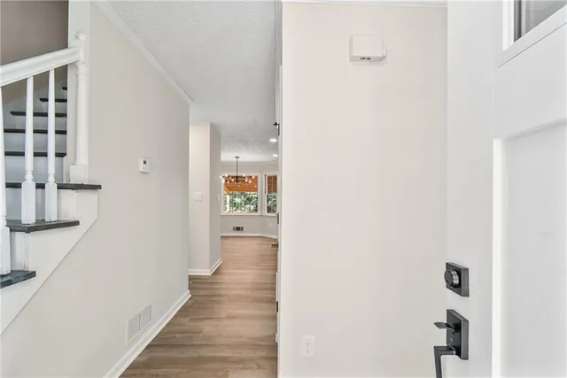 a view of a hallway with wooden floor and staircase