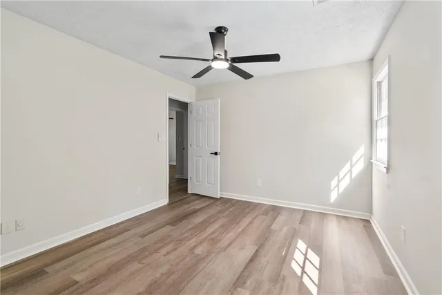 a view of empty room with wooden floor