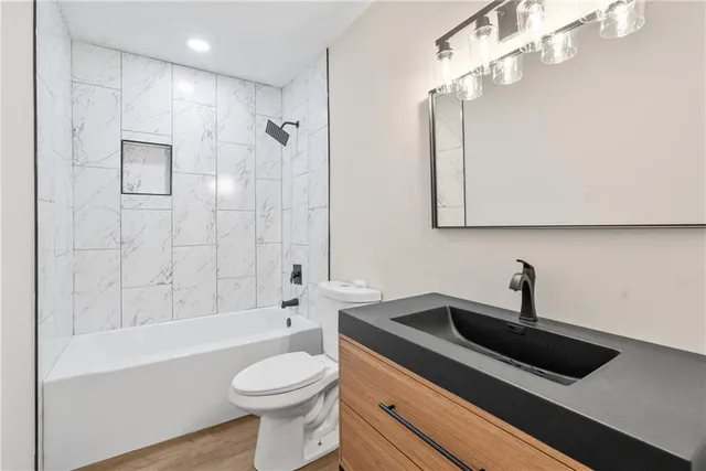 a bathroom with a sink a toilet and shower