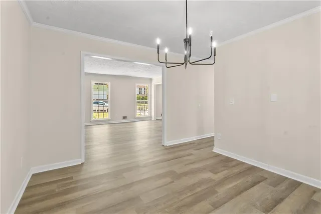 a view of a livingroom with wooden floor kitchen view and a window