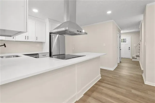 a kitchen with stainless steel appliances a refrigerator and wooden floor