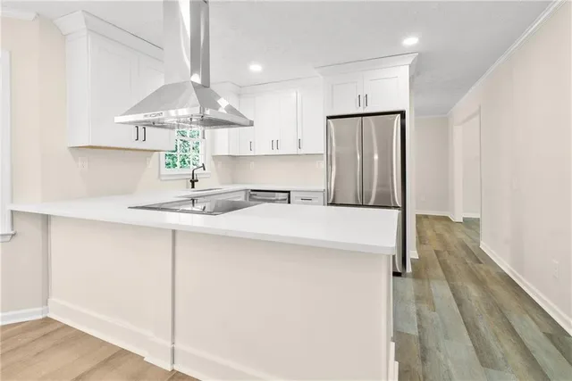 a kitchen with stainless steel appliances a sink cabinets and wooden floor
