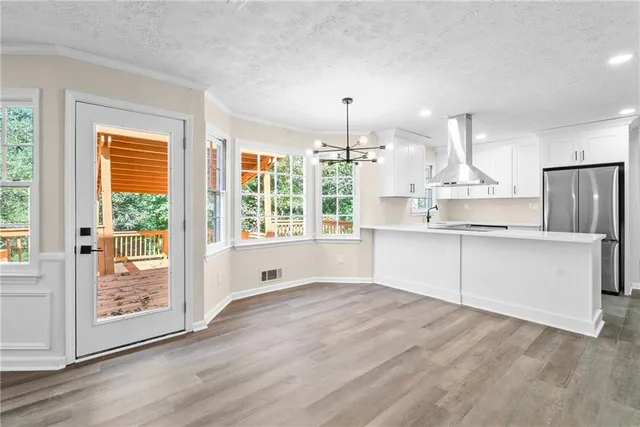 a large kitchen with kitchen island a large window appliances and cabinets