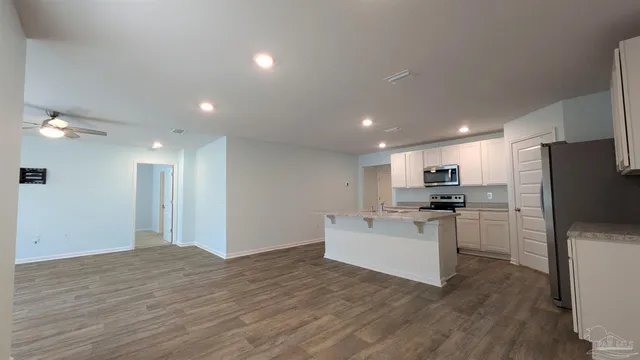 a view of kitchen with refrigerator stove microwave and cabinets
