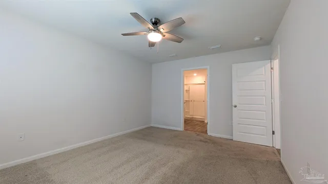 an empty room with closet and ceiling fan