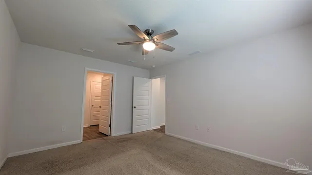 an empty room with closet and a chandelier fan