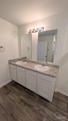 a bathroom with a granite countertop sink and a mirror