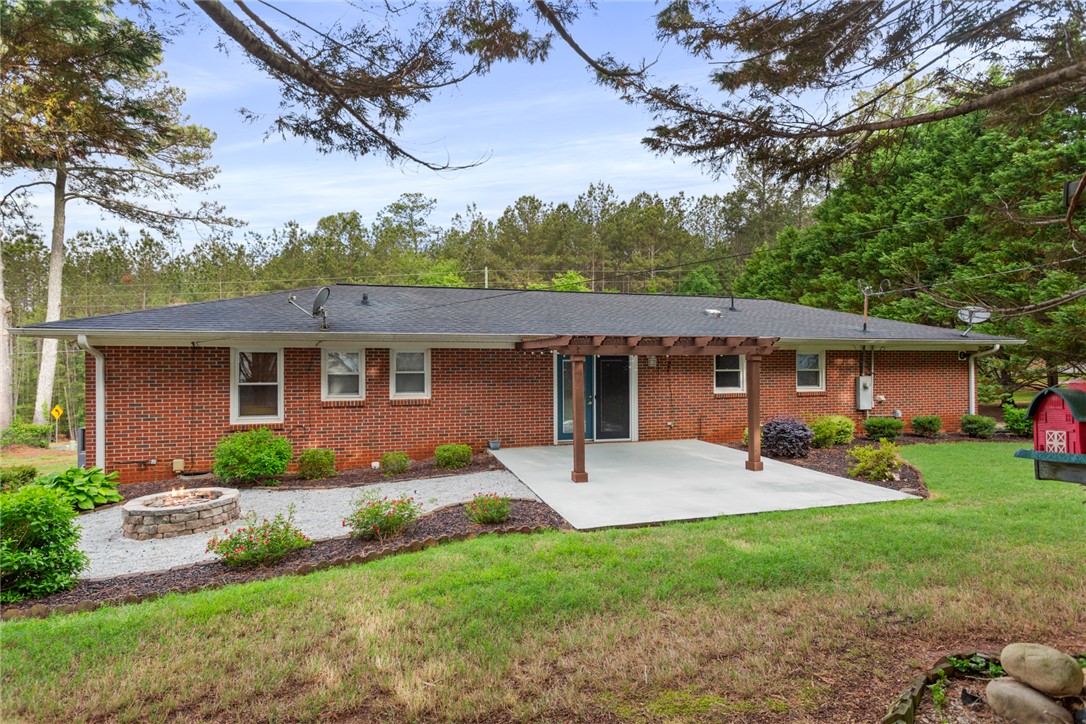 202 Keowee Trail Seneca, SC 29672 - Photo 24 of 35 The brick exterior home features a patio, pergola, and fire pit for outdoor enjoyment.