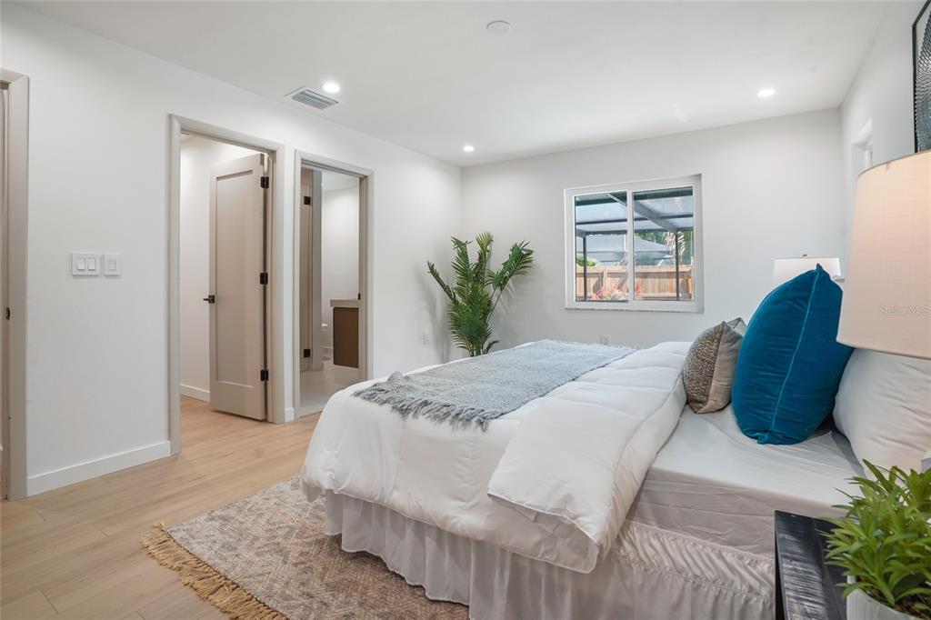 2370 Robyn Court Dunedin, FL 34698 - Photo 17 of 37 a bedroom with a large bed and a potted plant