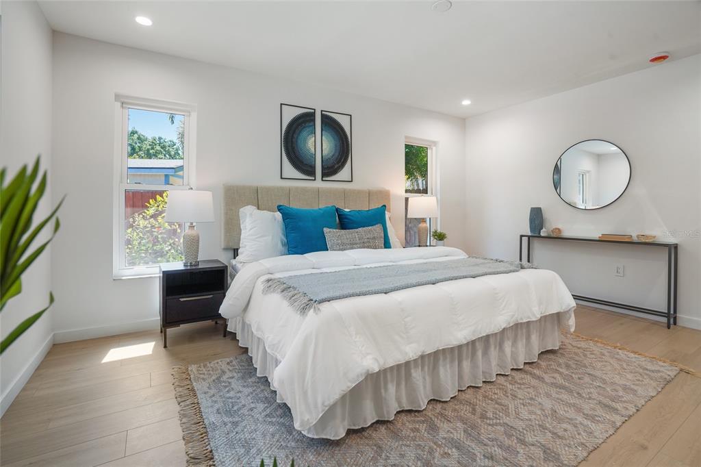 2370 Robyn Court Dunedin, FL 34698 - Photo 18 of 37 a bedroom with a large bed and a flat tv screen on dresser