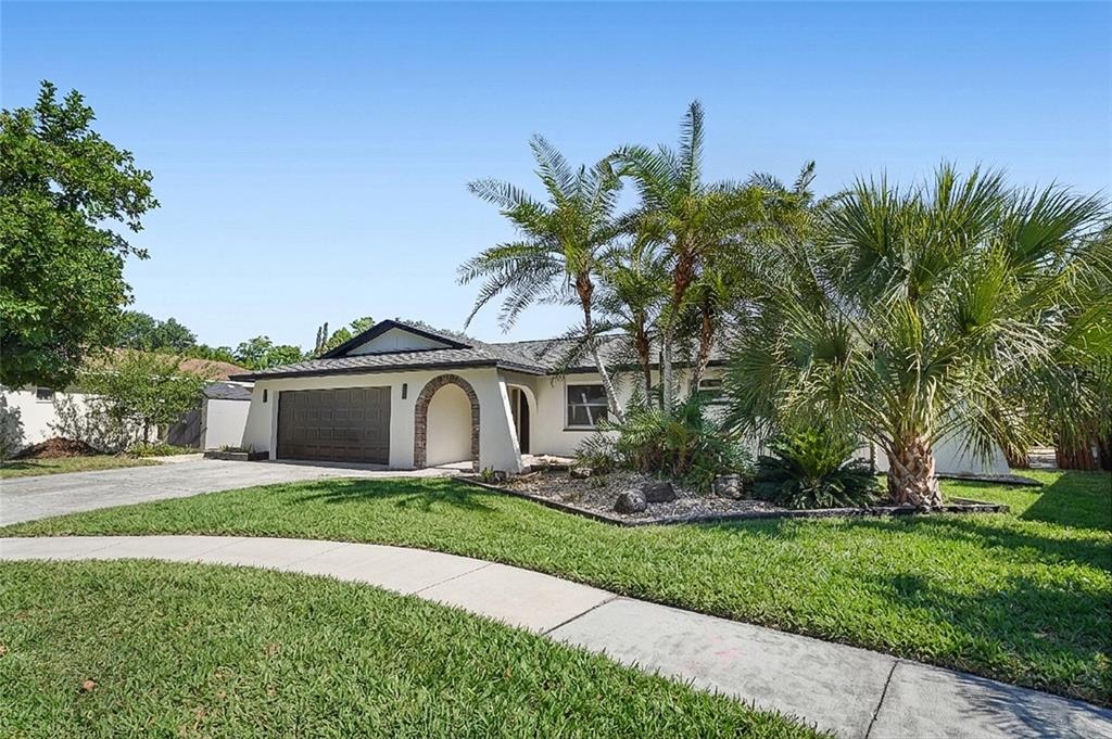 2370 Robyn Court Dunedin, FL 34698 - Photo 2 of 37 a front view of a house with a yard and garage