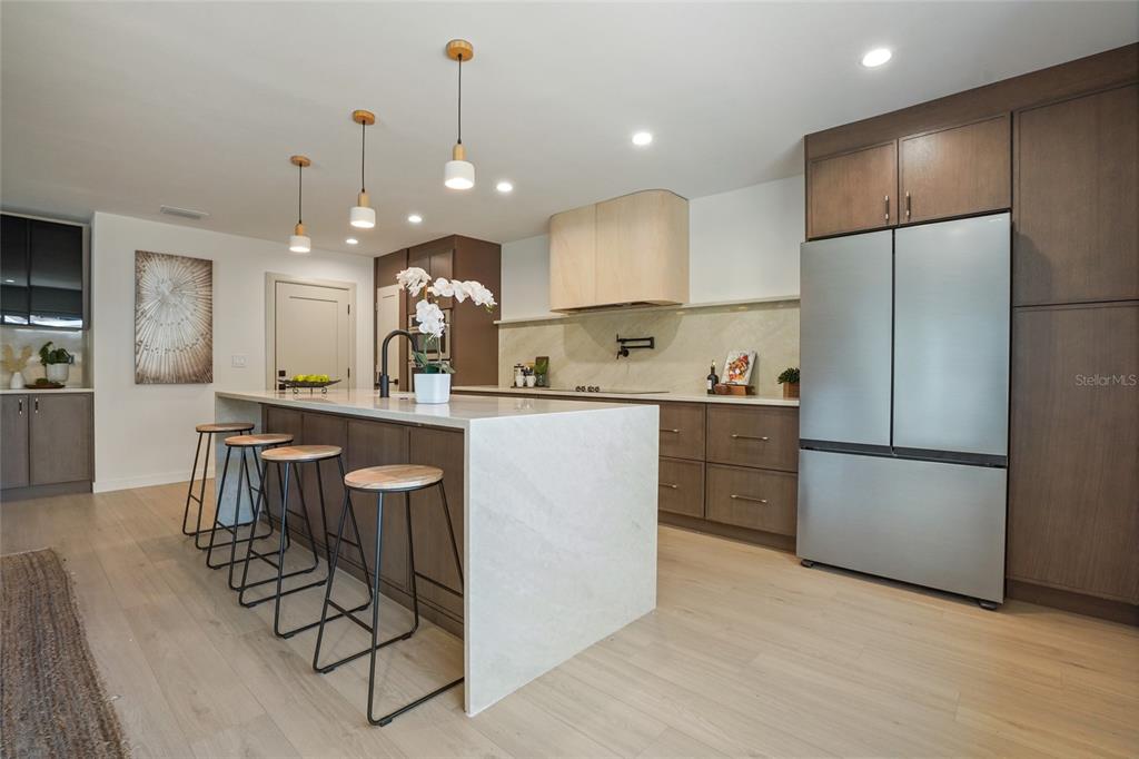 2370 Robyn Court Dunedin, FL 34698 - Photo 8 of 37 a kitchen with stainless steel appliances granite countertop a refrigerator a sink a stove a dining table and chairs