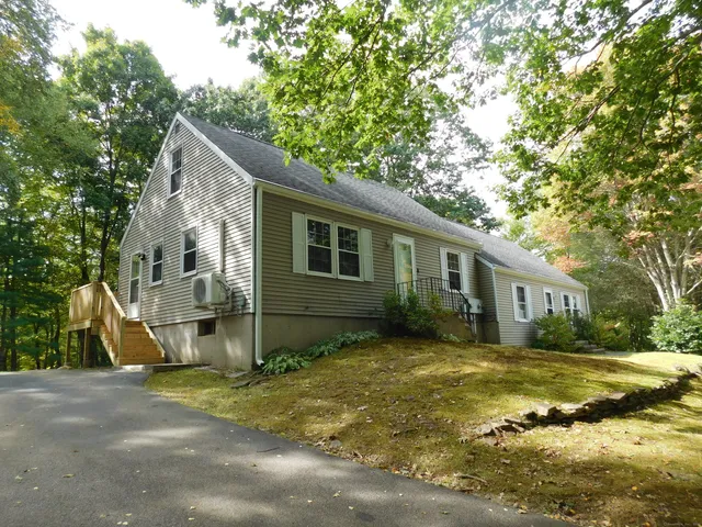 a view of a yard in front of a house with large trees