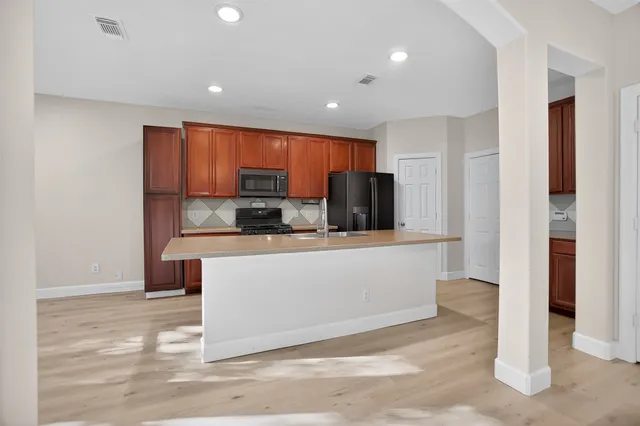a view of kitchen with stainless steel appliances cabinets