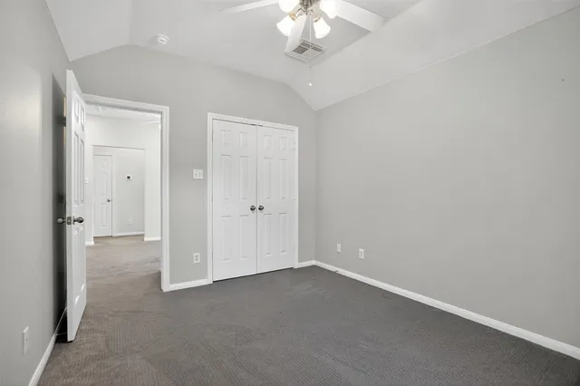 a view of an empty room with a chandelier fan