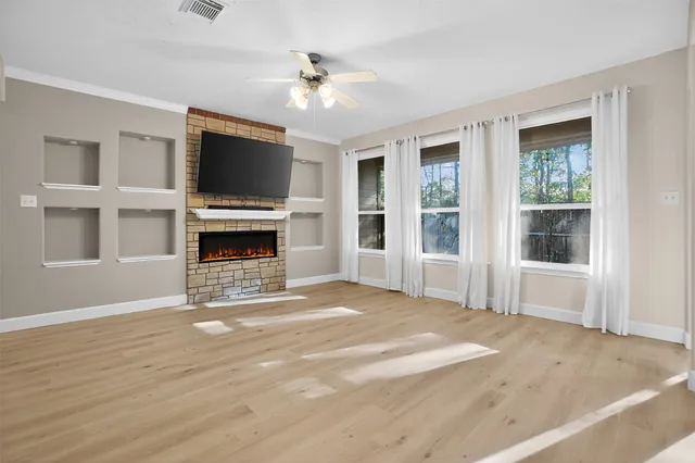 a view of an empty room with a fireplace and a window
