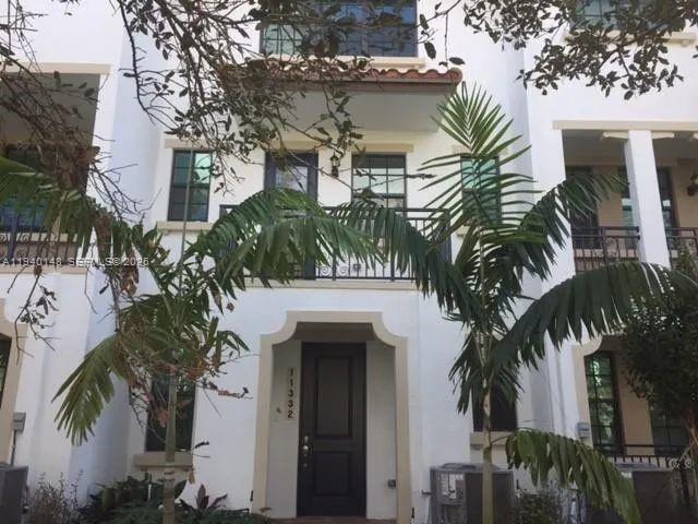 a front view of a house with a tree