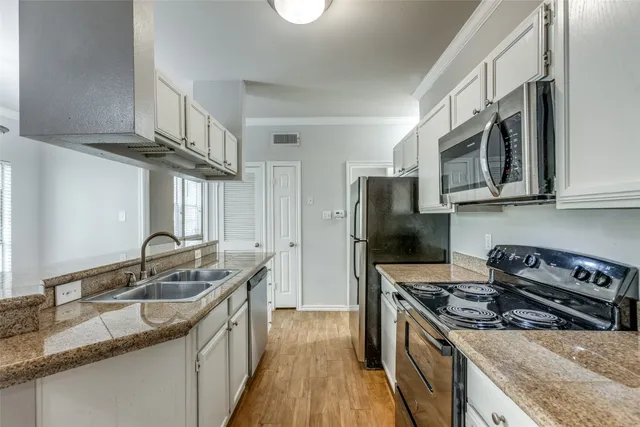 a kitchen with stainless steel appliances granite countertop a sink stove microwave and refrigerator