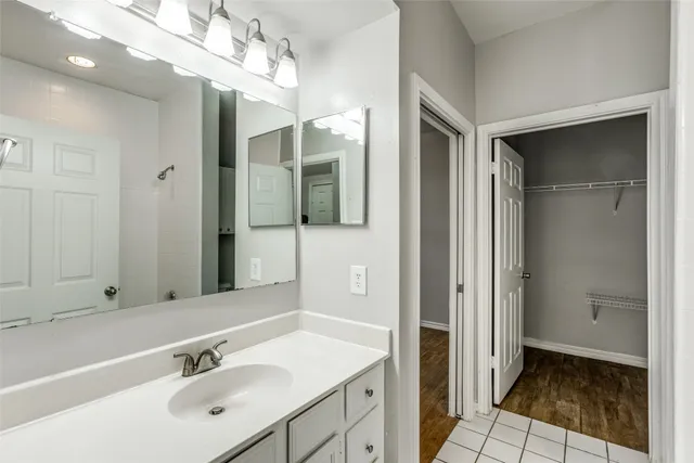a bathroom with a sink shower and a mirror