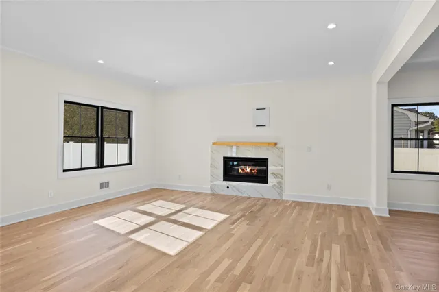 a view of empty room with wooden floor and fireplace
