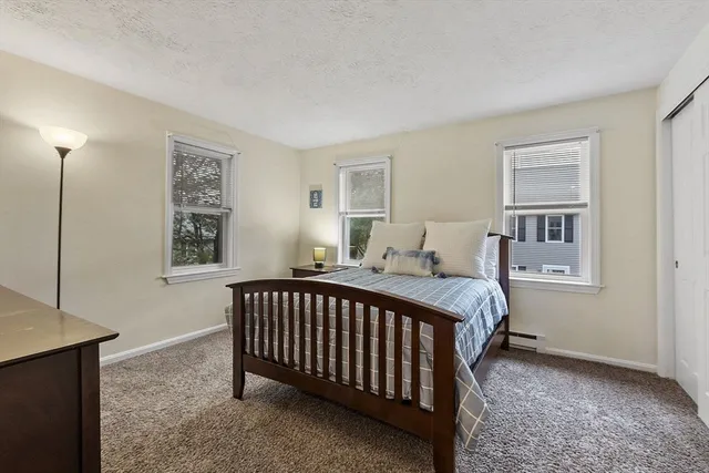 a bed sitting in a bedroom next to a window