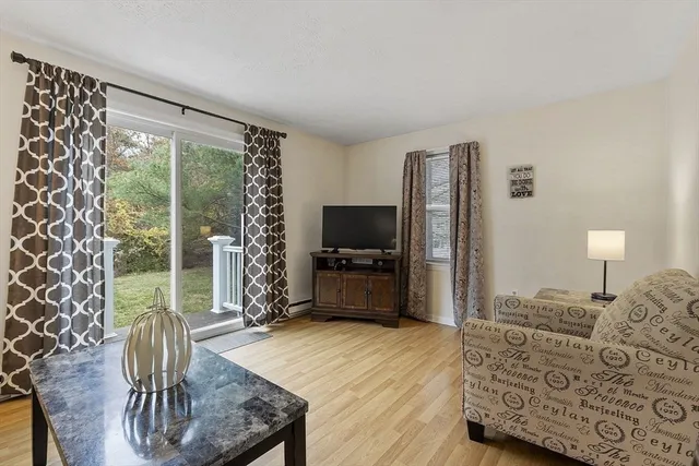 a living room with furniture a flat screen tv and a floor to ceiling window