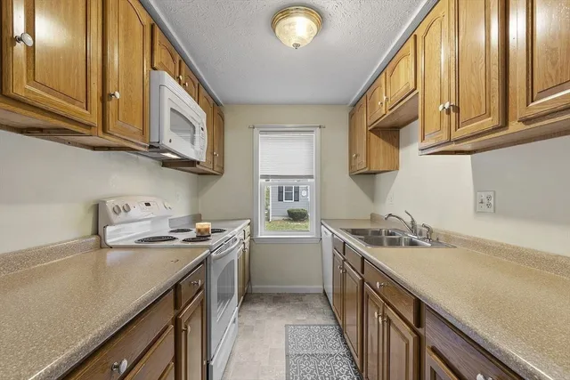 a kitchen with stainless steel appliances granite countertop a sink a stove and cabinets