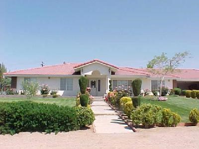 16340 Wintun Road Apple Valley, CA 92307 - Photo 1 of 1 a front view of a house with a garden and patio