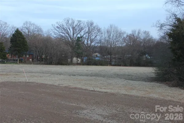 a view of dirt yard with trees