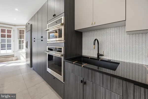 a dining hall with stainless steel appliances granite countertop a stove and a sink