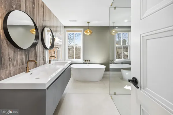 a bathroom with a bathtub a mirror and a sink